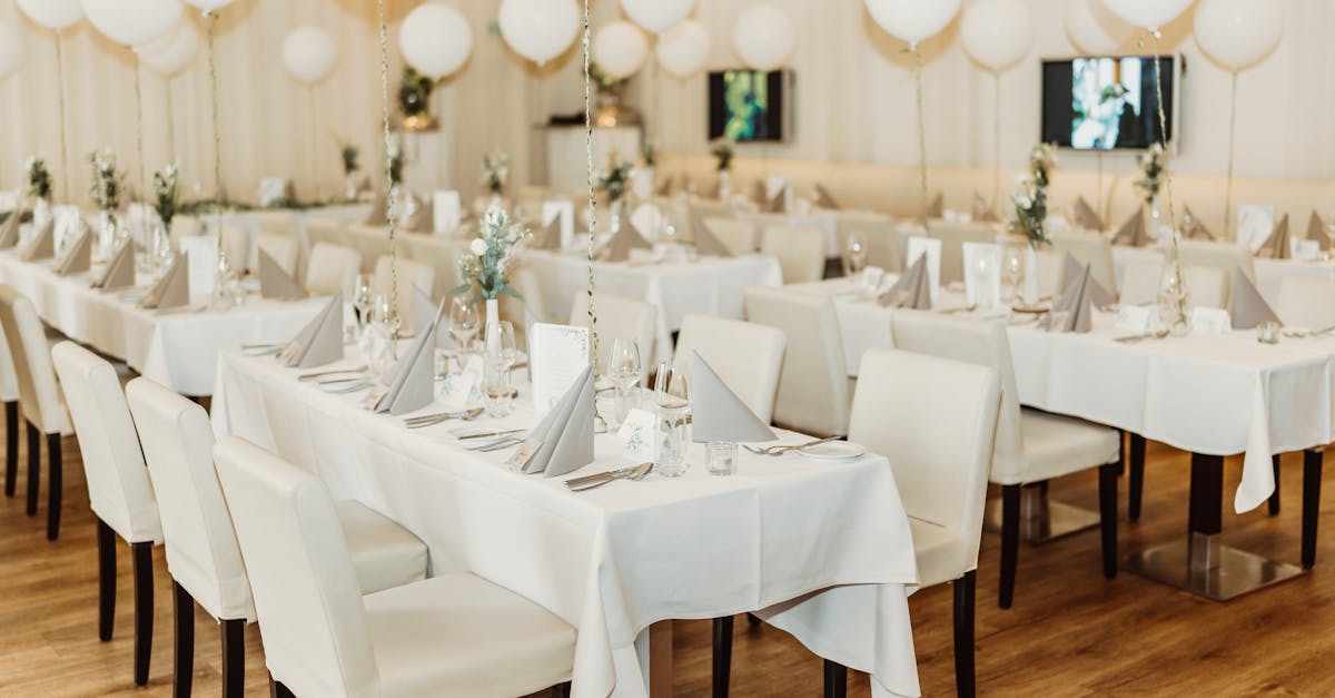 Stylish wedding reception setup in a restaurant with balloons and white theme decor.