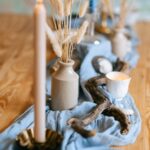 Beautiful coastal inspired tablescape with candles, driftwood, and seagrass decor.
