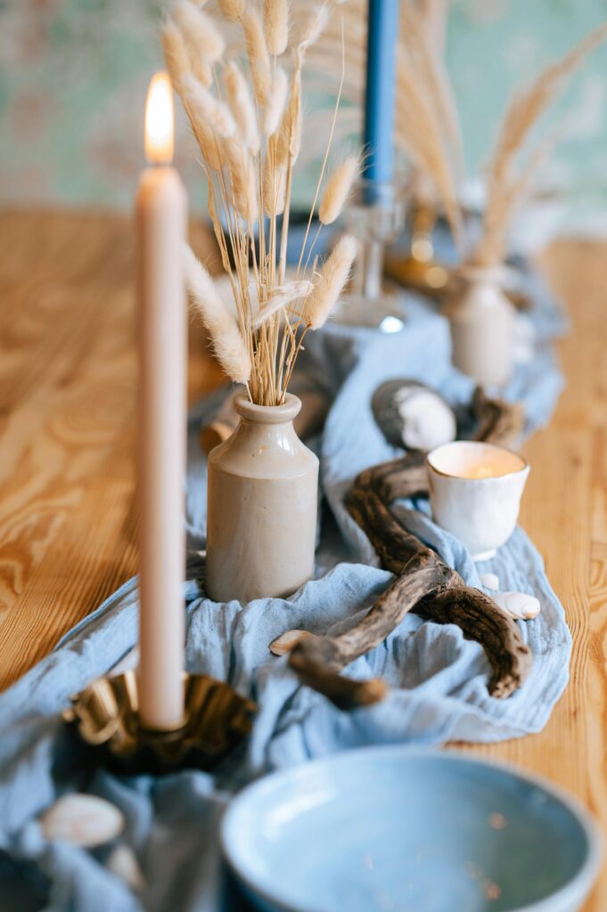 Beautiful coastal inspired tablescape with candles, driftwood, and seagrass decor.
