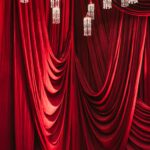 Stunning red drapery adorned with crystal chandeliers, perfect for luxurious interior decor.