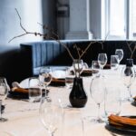 Elegant minimalist table setup with glasses, plates, and centerpiece.
