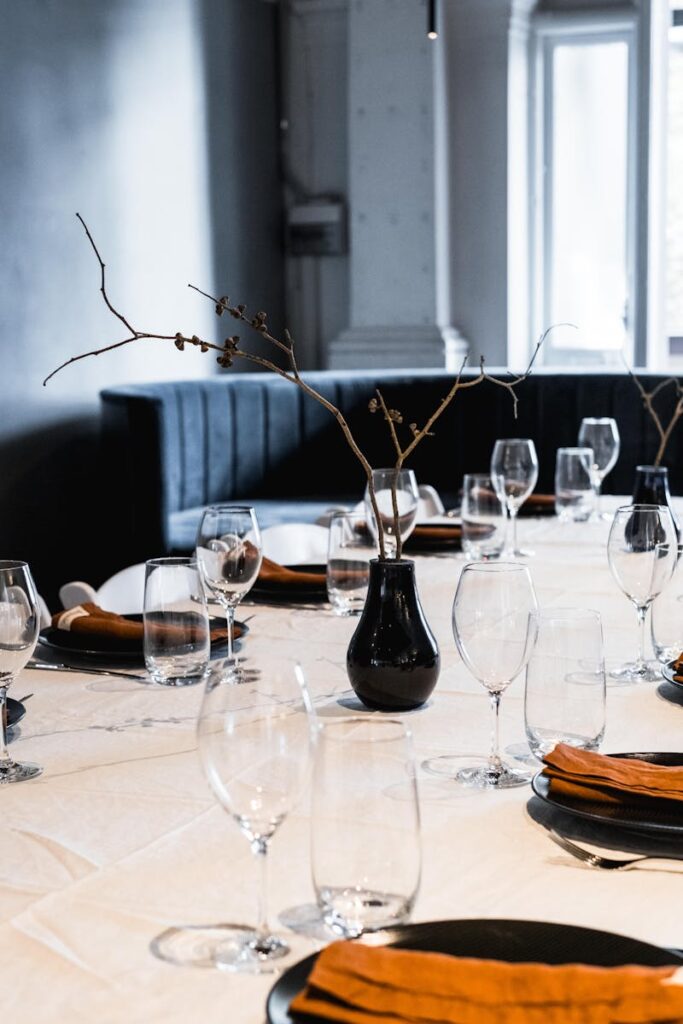 Elegant minimalist table setup with glasses, plates, and centerpiece.
