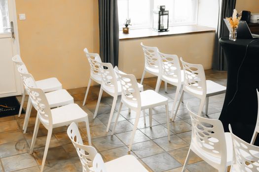 Modern conference room setup with white chairs arranged neatly.